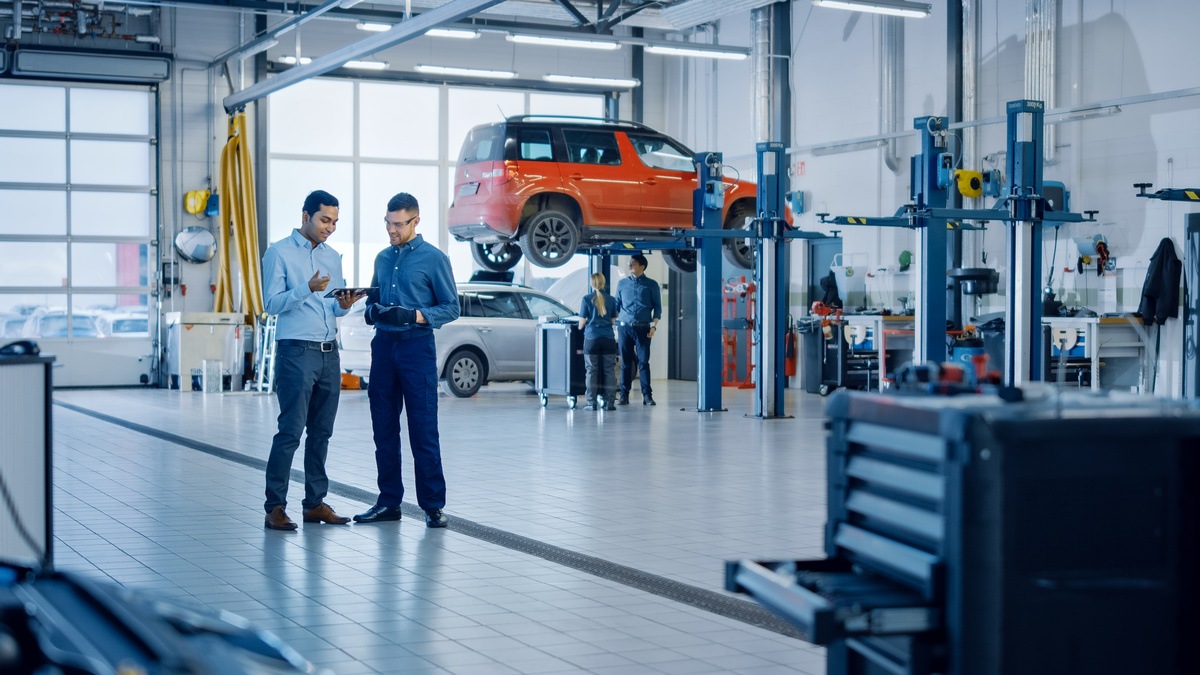 auto body shop owner and employees working together